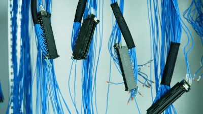 Close-up of blue ethernet cables hanging in a data center, highlighting technology connections.