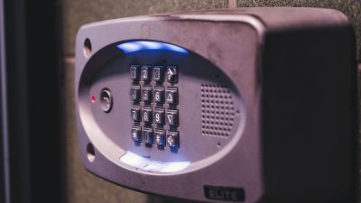 Illuminated security keypad mounted on a wall.