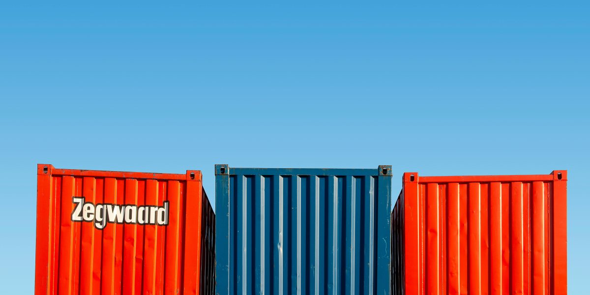 Brightly colored shipping containers stacked against a clear blue sky.