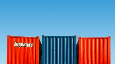 Brightly colored shipping containers stacked against a clear blue sky.
